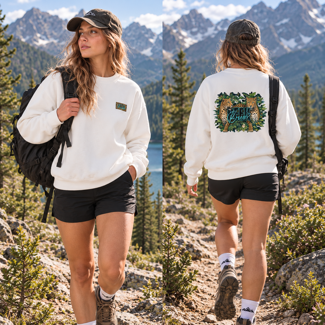  Femme portant le crewneck WILD blanc avec un sac à dos sur un sentier de montagne, vue de face et de dos.