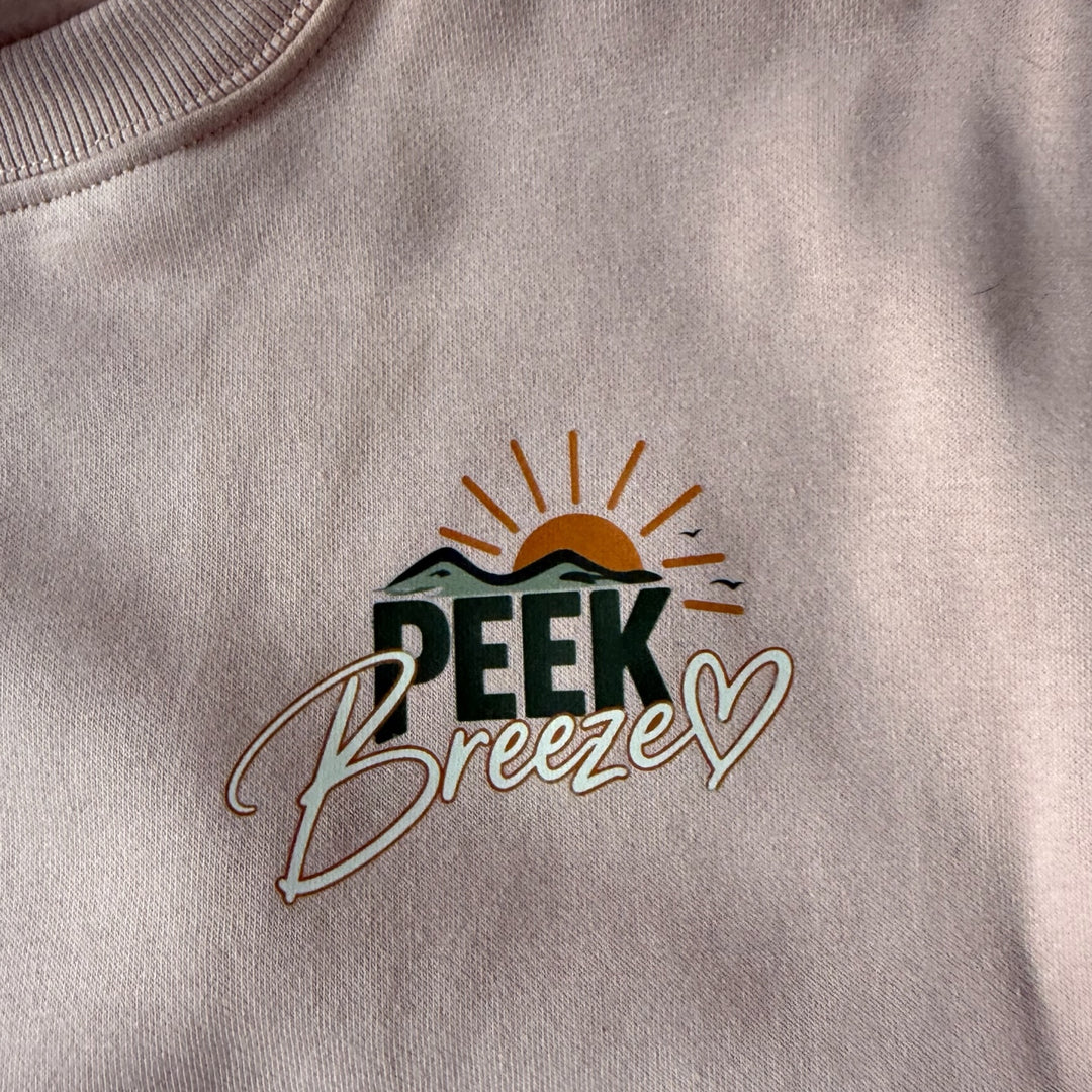 Gros plan du logo Peek Breeze imprimé sur la poitrine du Crewneck Coastal, chandail en coton ouaté pour femme.