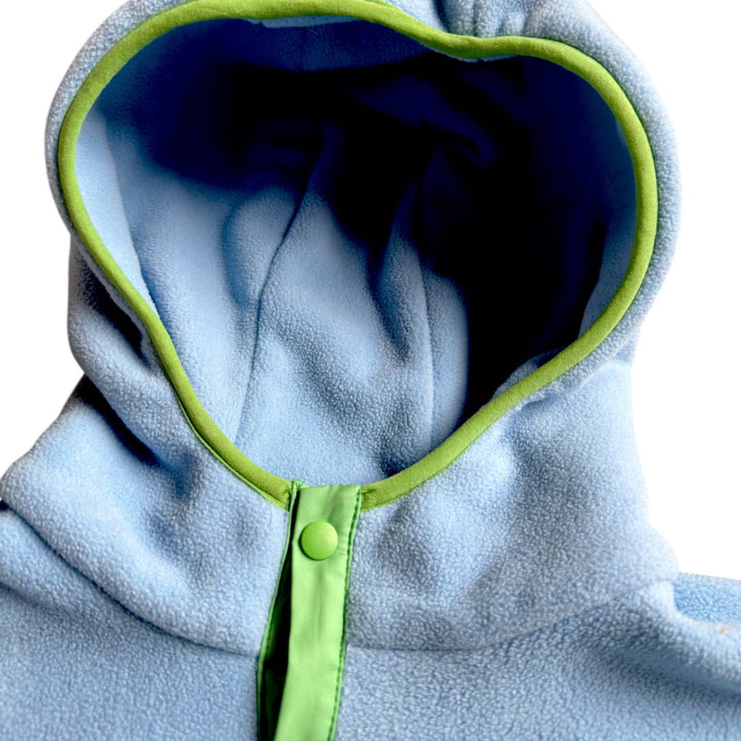 Détail du capuchon de la robe polaire Seaside Peek Breeze, en polar bleu pâle avec doublure bleu marine, bordure vert lime et bouton-pression assorti.