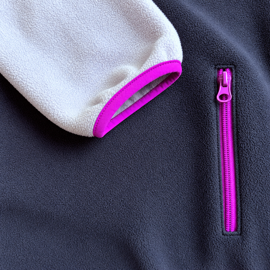 Détail de la poche zippée fuchsia sur le polar marine et du poignet lilas bordé de fuchsia, Peek Breeze